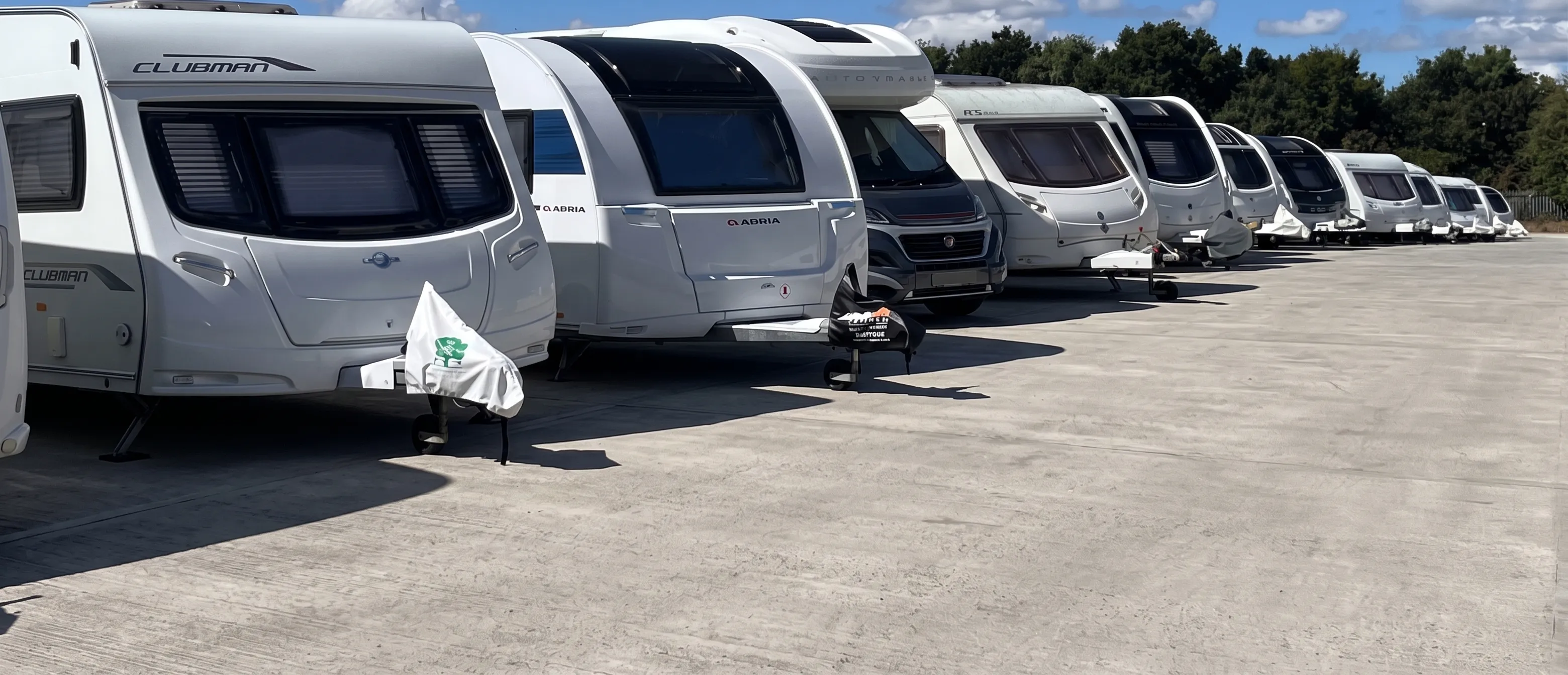 A row of caravans and motorhomes parked on the hardstanding compound at Hawcroft Grange